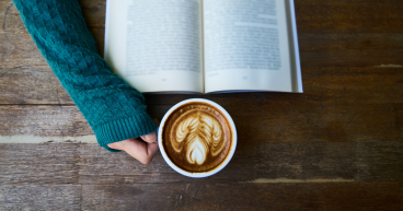 Canva - Person Having Cup of Latte While Reading Book